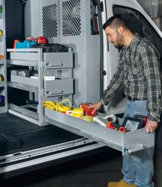 a man in plaid shirt loading items into the back of a truck