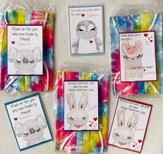 four greeting cards with pictures of animals and hearts on them, all in different colors