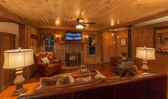 a living room filled with furniture and a flat screen tv mounted to the wall next to a fire place