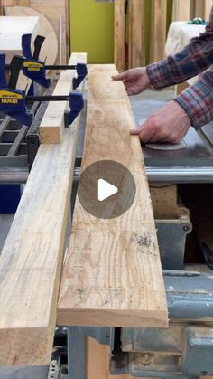 a man working on a piece of wood that is being cut with a planer