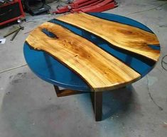 a table made out of wooden planks on top of a blue circular table in a garage