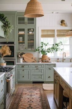 a kitchen with lots of green cabinets and rugs on the floor in front of it