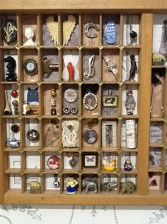 a wooden display case filled with lots of different types of buttons and bracelets on it