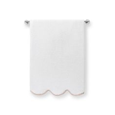 a white towel with scalloped edges hanging from a metal hook on a wall