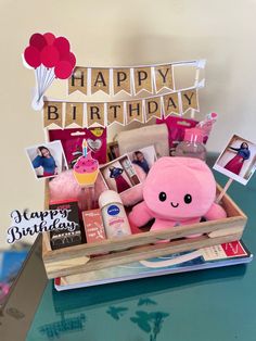 a pink stuffed animal sitting on top of a wooden box filled with personal care items