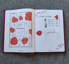 an open notebook with red flowers on it