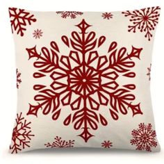 a red and white pillow with snowflakes on it