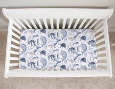 a white crib with an elephant and octopus print on it