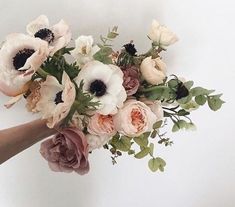 a person holding a bouquet of flowers in their hand