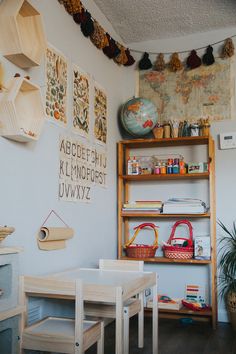 a room filled with lots of books and toys on top of shelves next to a wooden table