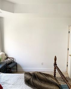 a bedroom with white walls and wooden furniture