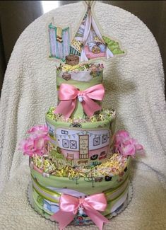 a three tiered cake with pink bows on the top is decorated like a house