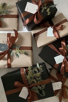 several wrapped presents with brown ribbons and flowers on them are sitting on the floor next to each other