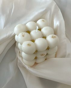 a bunch of white balls sitting on top of a white cloth covered in water droplets