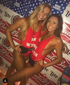 two beautiful young women standing next to each other in front of a coca cola sign