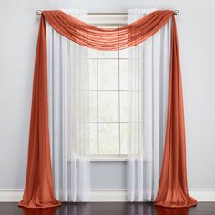 an orange and white curtain hanging in front of a window