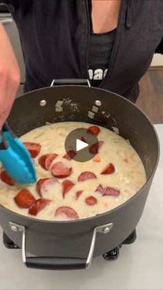 someone using a blue spatula to stir food in a skillet on the stove