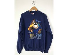 "-Description- >1995 Tasmanian Devil Dallas Cowboys fan or foe sweatshirt >crew neck pullover >size medium >perfect for a Cowboys fan! >condition: great >color(s): blue, brown, black, white >fabric(s): 50 cotton / 50 polyester >brand: league leader >care: machine wash -Measurements- >size: medium ✩ all measurements are taken with the item laying flat & some sizes are estimates so please check measurements ✩ chest: 39\" / 99cm length: 27\" / 68cm shoulder to slee Throwback Crew Neck Hoodie For Fan Merchandise, 90s Style Winter Sweatshirt For Fans, Throwback Fan Merchandise Sweatshirt For Sports Season, 90s Graphic Print Sweatshirt For Sports Season, 90s Style Long Sleeve Sweatshirt Fan Merchandise, 90s Crew Neck Sweatshirt For Sports Season, Vintage Graphic Print Sweatshirt For Fan Merchandise, Vintage Fan Merchandise Graphic Sweatshirt, Blue Crew Neck Sweatshirt For Fan Merchandise