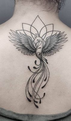 the back of a woman's neck with a bird and flower tattoo on it