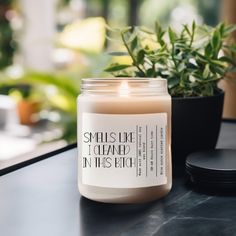 a candle sitting on top of a table next to a potted plant