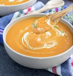 two bowls of soup with a wooden spoon