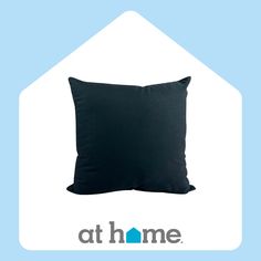 a black pillow sitting on top of a blue and white house shaped background with the words at home written below it