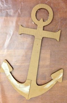 an anchor made out of cardboard sitting on top of a wooden table