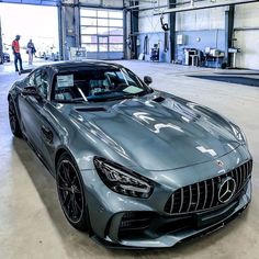 a silver mercedes sports car parked in a garage