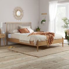 a bedroom with white walls and wooden floors