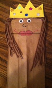 a paper bag with a cardboard doll wearing a crown