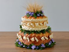 a three tiered cake decorated with flowers and grass