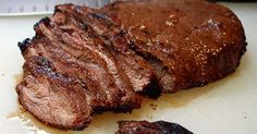 a piece of steak on a cutting board with some seasoning sprinkles