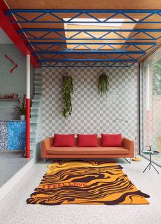 a living room with an orange couch and green rug on the floor in front of it