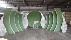 several large green and white sculptures in a warehouse