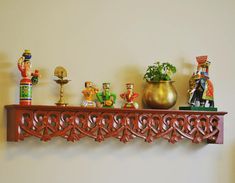 a shelf with figurines on top of it next to a potted plant