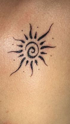 a sun tattoo on the back of a woman's shoulder and chest is shown