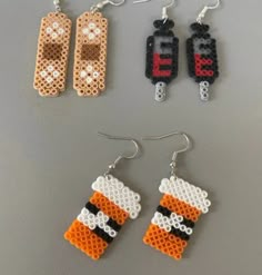 three pieces of beaded earrings are arranged on a table, one is made out of legos