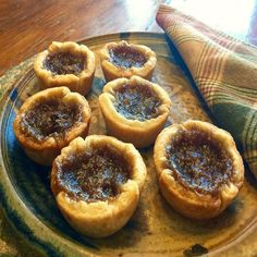 small pies are sitting on a plate next to a napkin