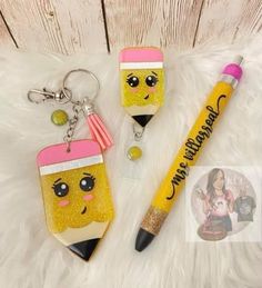 two key chains with different designs on them and a pen in the shape of a pencil