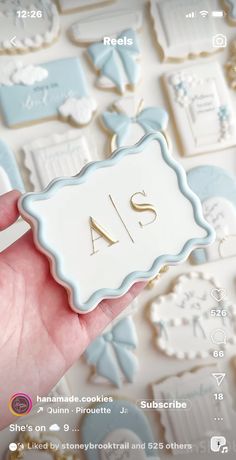 a person holding up a cookie with the word as on it in front of some cookies