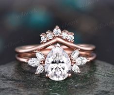 a rose gold engagement ring with a pear shaped diamond surrounded by three smaller pears