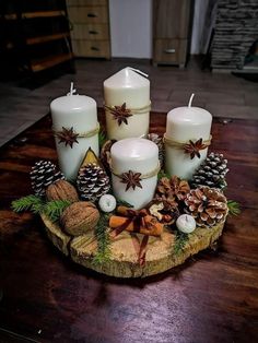 a wooden table topped with candles and pine cones