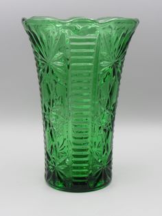 a green glass vase sitting on top of a table