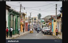 an old street with cars and people on it