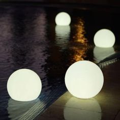 several white balls sitting on top of a swimming pool