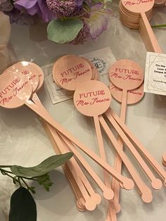 some wooden spoons are sitting on a table next to purple flowers and other items