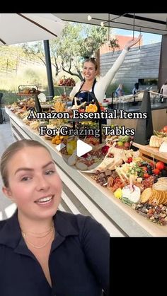 a woman is smiling while standing in front of a table full of food