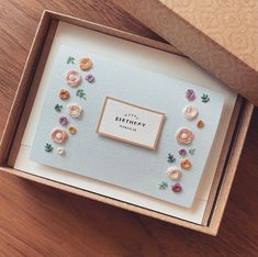 a birthday card in a box with flowers on it