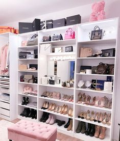 a white closet filled with lots of shoes and handbags next to a pink bench