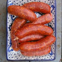 two blue and white plates with sausages on them